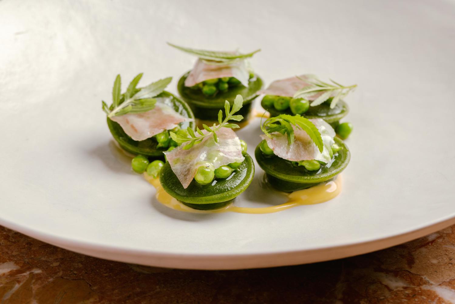 Bottoni with spinach, guanciale, honey peas and egg emulsion.