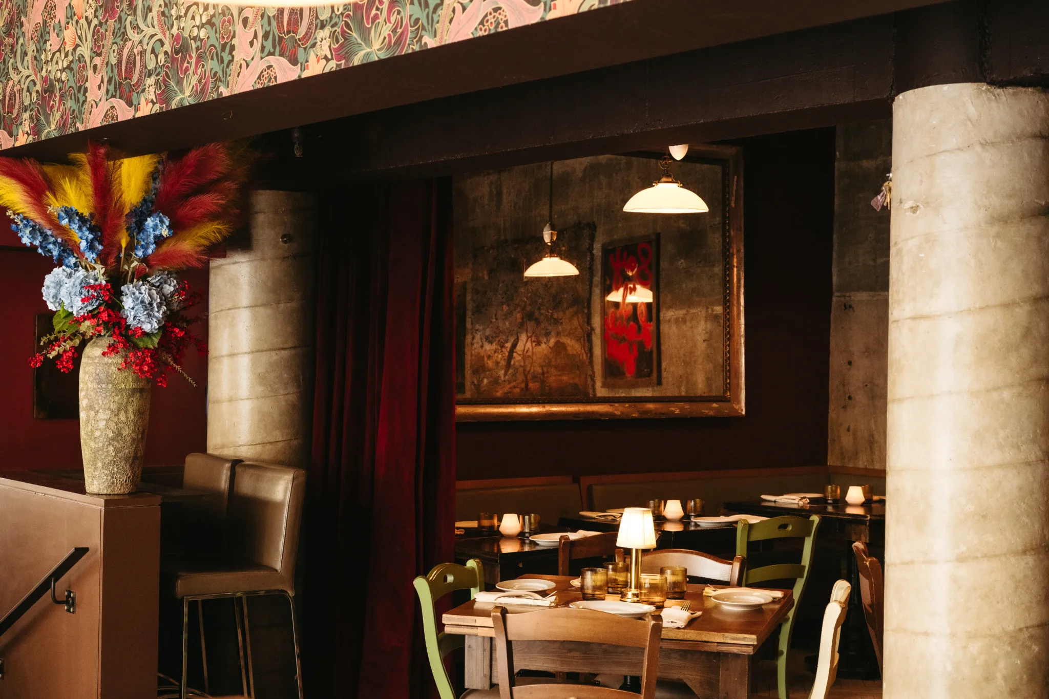 Piccolo Morini restaurant features a set table, soft lighting, vase of flowers, and decorative artwork.