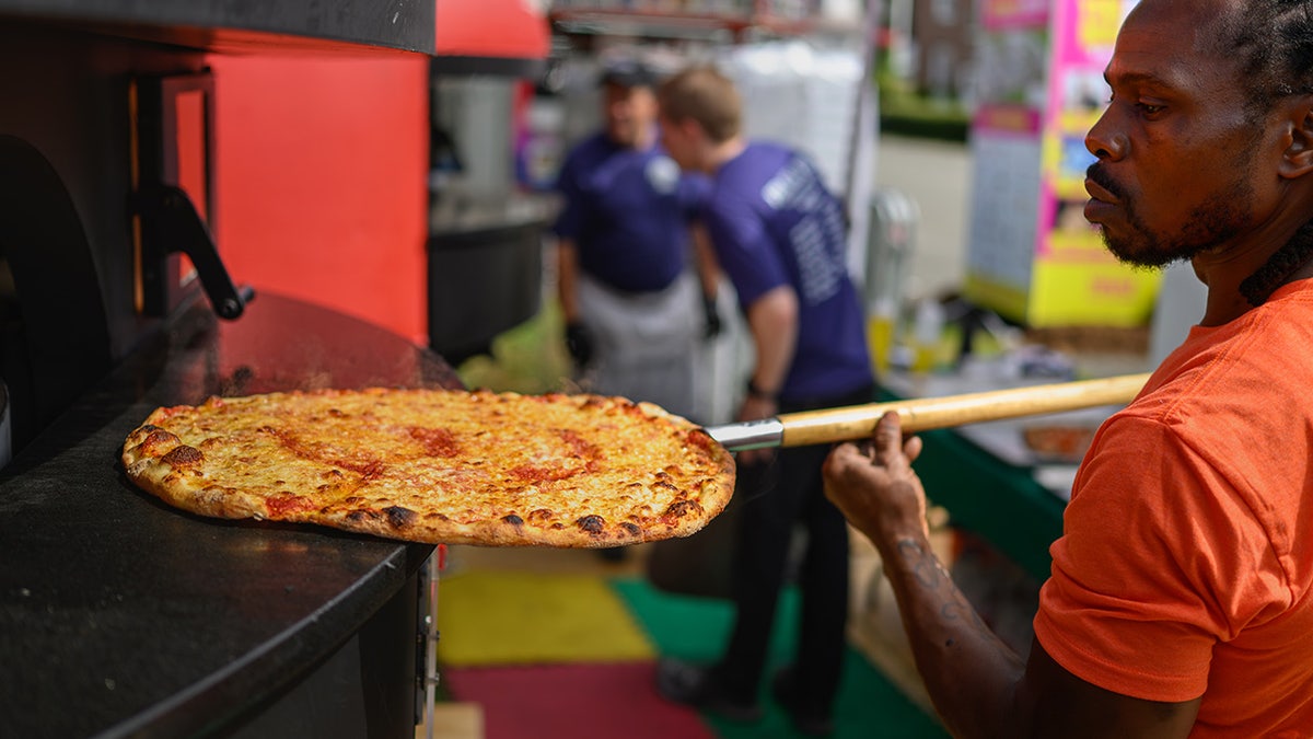 September 17, 2025 - Springfield, Ma. - Dwayne Miller, a master cook with Frank Pepe's in New Haven checks on a pizza baking at The Big E. Kevin Galliard, who 