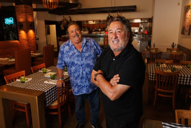 Joe Busalacchi Sr. (right) and his brother Frank Busalacchi pose at Barbusa in Little Italy. The company is celebrating its 40th anniversary. (Kristian Carreon / The San Diego Union-Tribune)